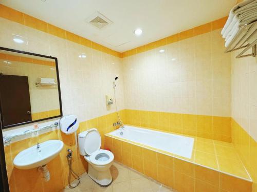 ein Badezimmer mit einer Badewanne, einem WC und einem Waschbecken in der Unterkunft GRAND FAR EAST HOTEL SDN BHD in Masai
