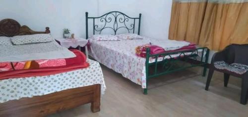 sypialnia z 2 łóżkami, stołem i krzesłami w obiekcie Sultan Tit w mieście Jyoti Gaon