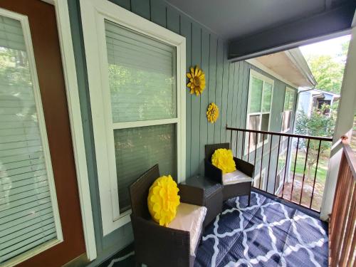 a screened porch with two chairs and yellow bows at A Touch of Sunshine Ideal For Long Term Stays in Fayetteville