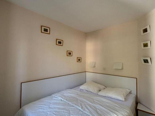 une chambre avec un lit avec deux oreillers dessus dans l'établissement 2 pièces pour 4 avec piscine, parking et climatisation - FR-1-504-682, à Saint-Raphaël