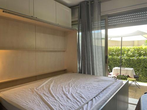 une chambre avec un lit et une grande fenêtre dans l'établissement Studio en Rez-de-Jardin à Cannes la Bocca – Accès Plages, Terrasse Privée - FR-1-609-98, à Cannes