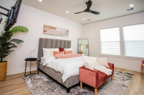 a bedroom with a large bed with a red chair at Stylish 3 Story Townhouse near East Downtown in Houston