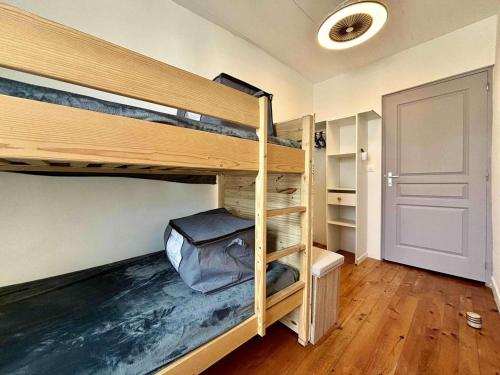 Cette chambre comprend 2 lits superposés et une porte. dans l'établissement Charmante Maison Rénovée avec Cour-WIFI Gratuit, 2 Chambres, Proche Commerces, Saint-Georges-d'Oléron - FR-1-246A-287, à Saint-Georges-dʼOléron