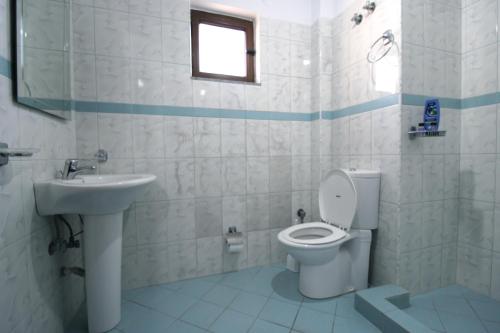 a bathroom with a toilet and a sink at Garden Villa Dhesara in Ksamil