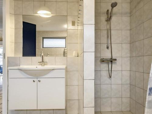 a bathroom with a sink and a shower at Four-Bedroom Holiday home in Væggerløse 22 in Marielyst