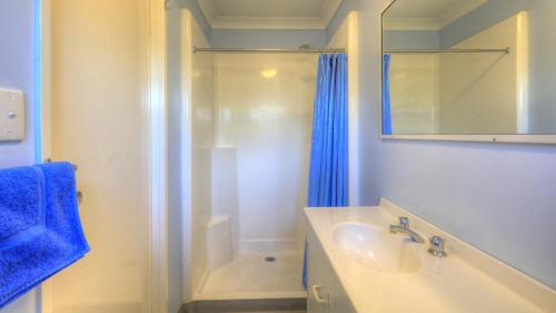 bagno bianco con doccia e lavandino di Barcaldine Caravan Park a Barcaldine