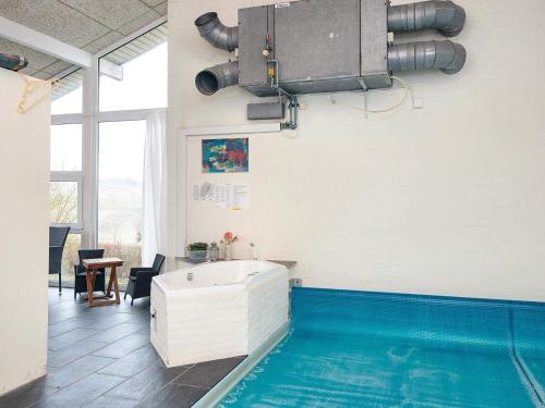 uma casa de banho com banheira ao lado de uma piscina em 10 person holiday home in Haderslev em Diernæs