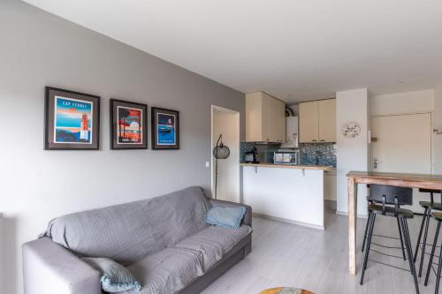 un salon avec un canapé et une cuisine dans l'établissement Appartement des Tchanquées - Welkeys, à Arcachon