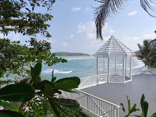 a gazebo on a boardwalk next to the ocean at Bhundhari Resort & Villas Samui in Chaweng