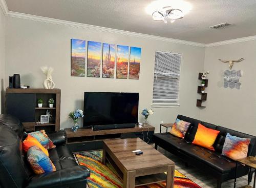 a living room with two leather couches and a flat screen tv at A Blissful Townhome with a Game Room Near AT&T Stadium, Six Flags, DFW Airport in Arlington