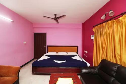 a bedroom with a bed and a couch at Hotel Soorya Inn in Puducherry