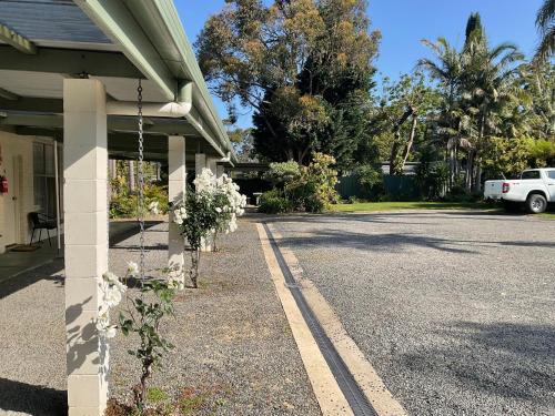 a house with a porch with a car parked in the driveway at Motel Bream in Mallacoota