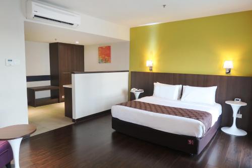 a hotel room with a large bed and a desk at Wyndham Garden i-City Shah Alam in Shah Alam