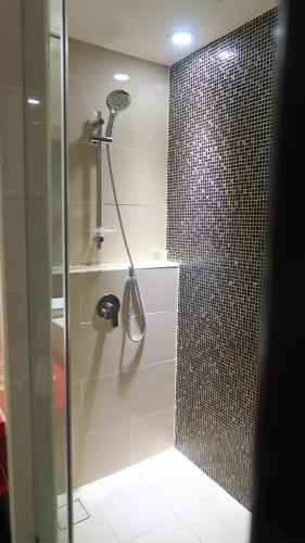 a bathroom with a shower with a shower head at Wyndham Garden i-City Shah Alam in Shah Alam