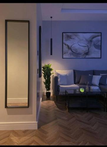ein Wohnzimmer mit einem Sofa und einem Spiegel in der Unterkunft شقة فاخرة بدخول ذاتي in Riad