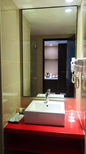 a bathroom with a white sink and a mirror at Wyndham Garden i-City Shah Alam in Shah Alam