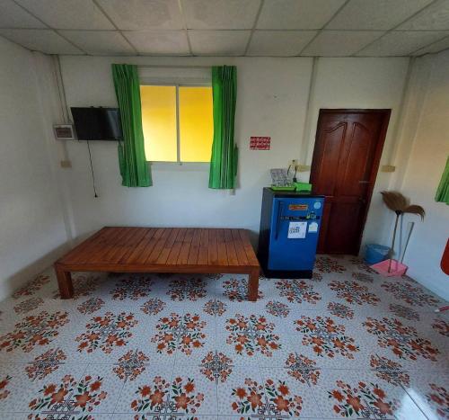 Habitación con mesa de madera en una habitación en โรงแรมดาวทองรีสอร์ทมหาสารคาม, en Ban Nong Chik