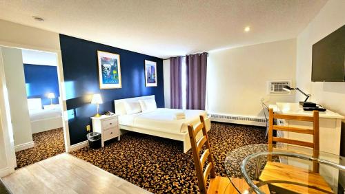 a bedroom with a bed and a desk in a room at Cloud 9 Inn in Whitecourt