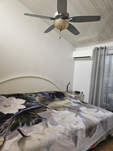 a bedroom with a ceiling fan and a bed at Very cozy beautifully designed loft apartment in Coco