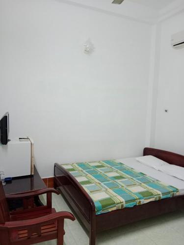um quarto com uma cama, uma secretária e uma cadeira em Khách sạn Hải Vân em Hà Tiên