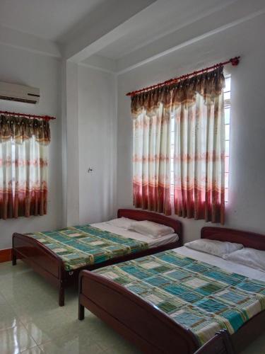 2 camas en una habitación con ventana en Khách sạn Hải Vân, en Hà Tiên