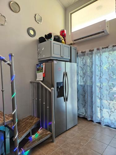 a kitchen with a stainless steel refrigerator in a room at Very cozy beautifully designed loft apartment in Coco