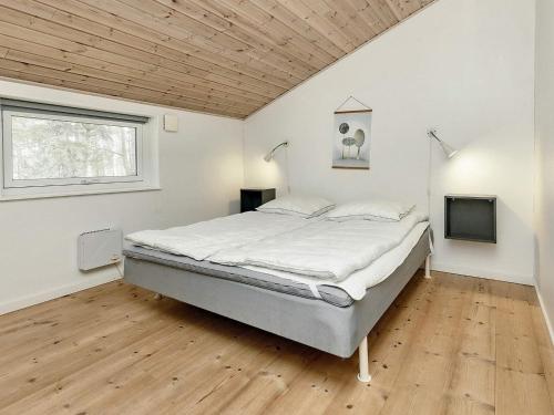 a large bed in a room with a wooden ceiling at Holiday home Rødby LVI in Rødby