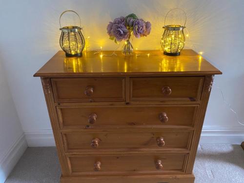 a dresser with two candles and two vases with flowers on it at North Street Flat in Bristol