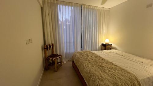 a bedroom with a bed and a large window at Luminoso departamento con cochera en San Isidro in San Isidro