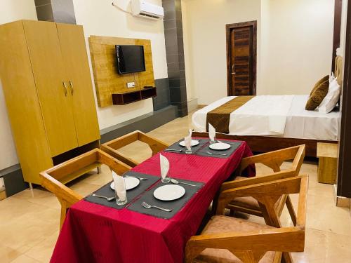 a room with a table and chairs and a bed at Hotel Fusion in Kurukshetra