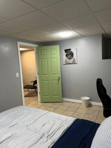 Zimmer mit einem Bett und einer grünen Tür in der Unterkunft 305-B. Studio in Tremont