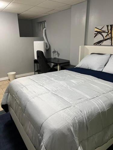 ein Schlafzimmer mit einem großen weißen Bett und einem Tisch in der Unterkunft 305-B. Studio in Tremont