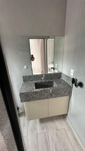 a bathroom with a sink and a mirror at Recanto S.A in Corumbazul