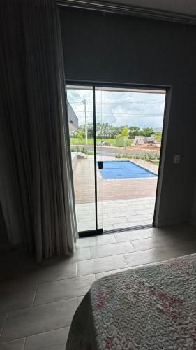 1 dormitorio con ventana grande con vistas a la piscina en Recanto S.A, en Corumbazul