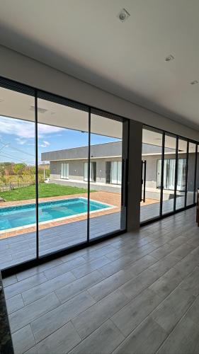an empty house with glass doors and a swimming pool at Recanto S.A in Corumbazul