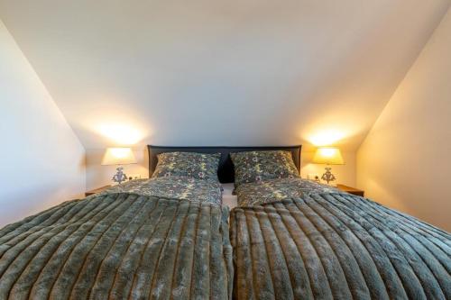 two beds in a bedroom with two lamps at Villa Heimathafen Rügen - Luxus gepaart mit Wellness in Lohme
