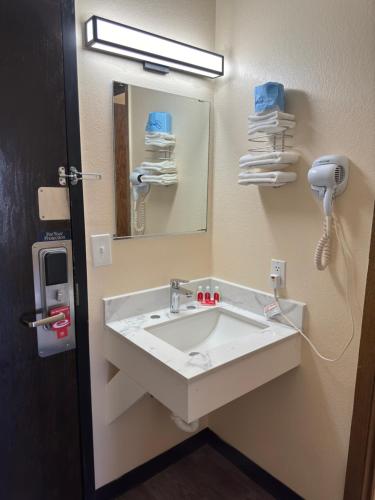 a bathroom with a sink with a mirror and a phone at Econo Lodge in Waite Park