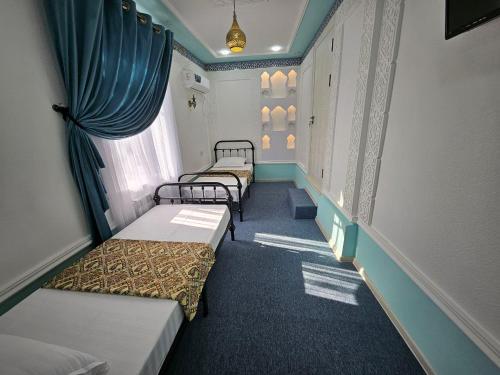 un pasillo con 4 camas en una habitación en Guest house Gula en Samarcanda