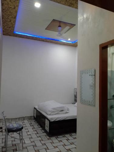 a bed in a room with a blue light on the ceiling at CHOICE HOTEL AND RESTAURANT in Hanumāngarh