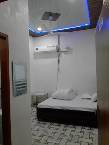 1 dormitorio con 1 cama con una luz azul en el techo en CHOICE HOTEL AND RESTAURANT, en Hanumāngarh
