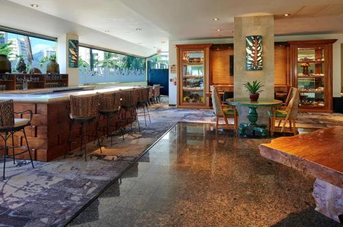 a bar in a restaurant with a row of bar stools at Luana Waikiki Hotel in Honolulu