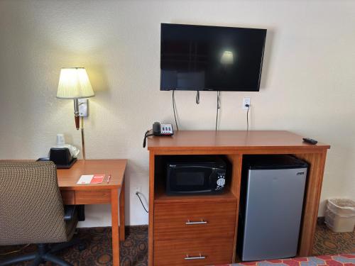 a room with a desk and a tv on top of a hotel room at Econo Lodge in Waite Park