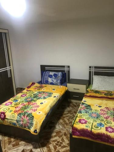 duas camas sentadas uma ao lado da outra num quarto em Taiky em Um Qeis