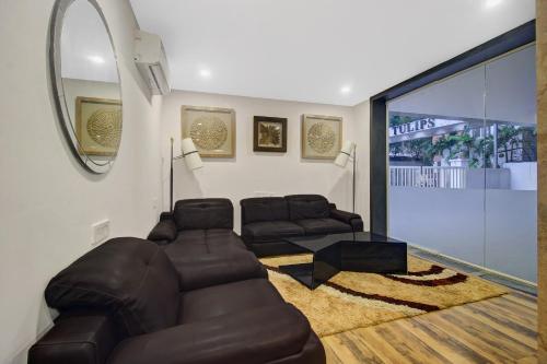 a living room with leather furniture and a large window at Townhouse Hitec City Near Image Hospital in Hyderabad