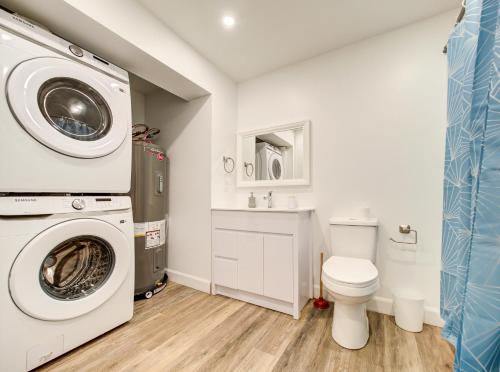 a bathroom with a washing machine and a toilet at Cozy & Luxurious 3-BR condo (4min to metro) in Montreal