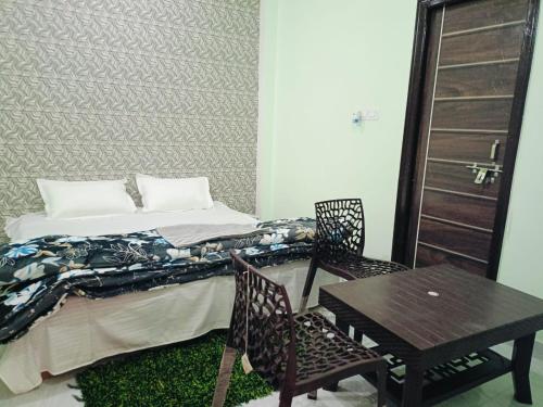1 dormitorio con 1 cama, mesa y sillas en Siya home stay en Faizābād