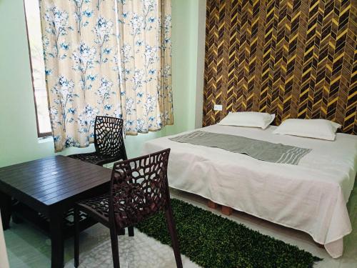 a bedroom with a bed and a table and chairs at Siya home stay in Faizābād