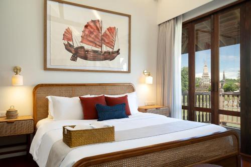 a bedroom with a large bed with a boat on it at Syama Residence and Café in Phra Nakhon Si Ayutthaya