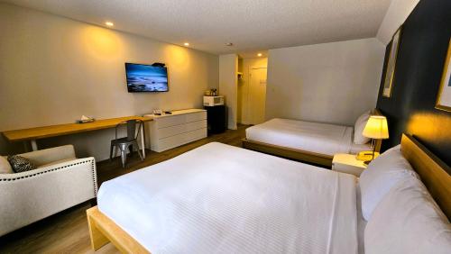 a hotel room with two beds and a desk at Cloud 9 Inn in Whitecourt