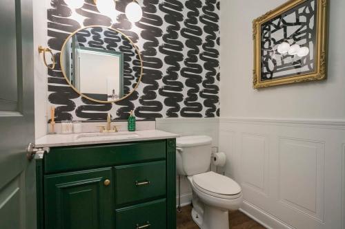 a bathroom with a green cabinet and a mirror at Broadway Penthouse Above Live Music & Bars in Nashville